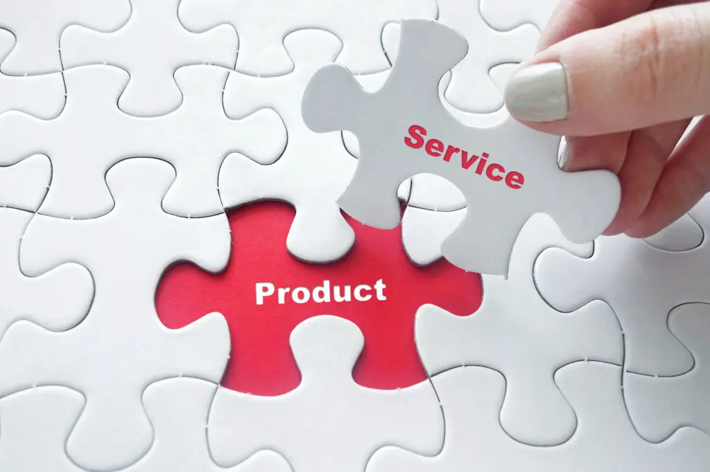 Close up of girl's hand placing the last jigsaw puzzle piece with word Product and Service as business concept